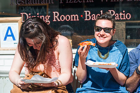 two women eating pizza