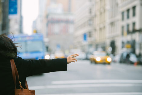 a woman waiving for a taxi